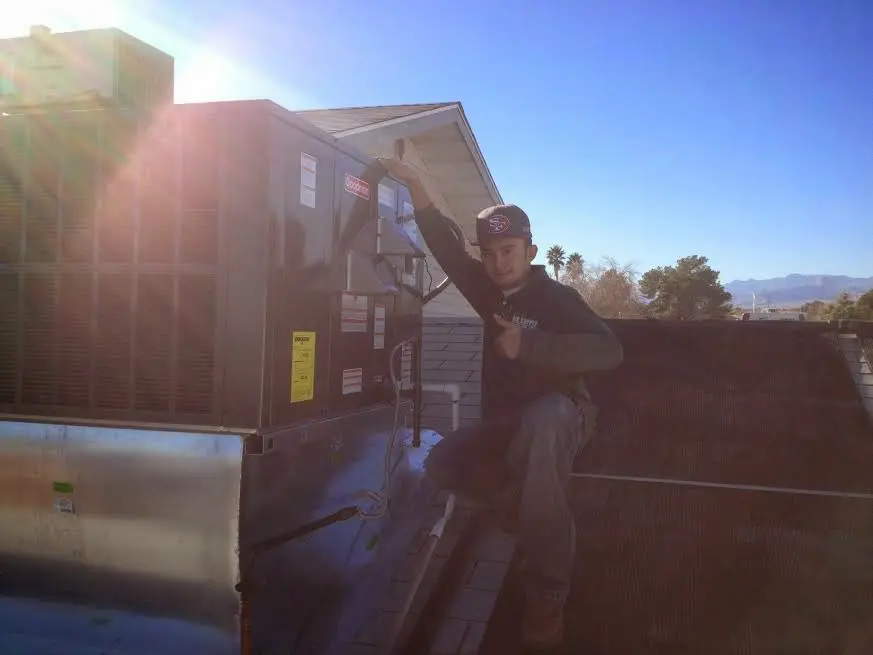 HVAC technician performing AC Tune-Up on a rooftop unit in Decorah